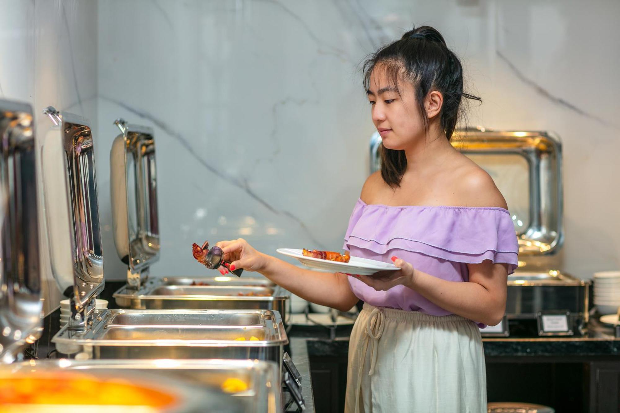 May De Ville Lakeside Hotel Hanoi Luaran gambar A woman serving herself at a buffet